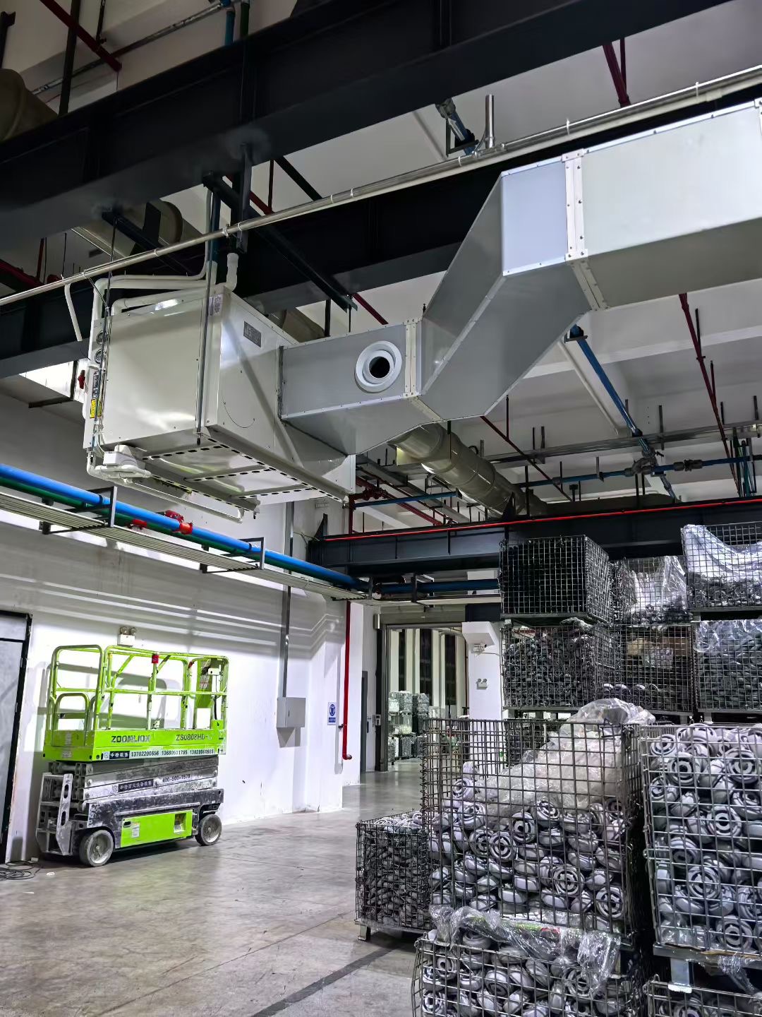 Overhead energy saving air conditioner connected to metal ductwork in a factory